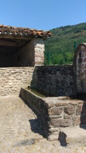 Elbeteko lisutegi ondoan daude aska eta iturria